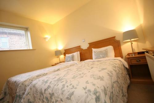 a bedroom with a large bed and a window at Crown Hotel in Nantwich