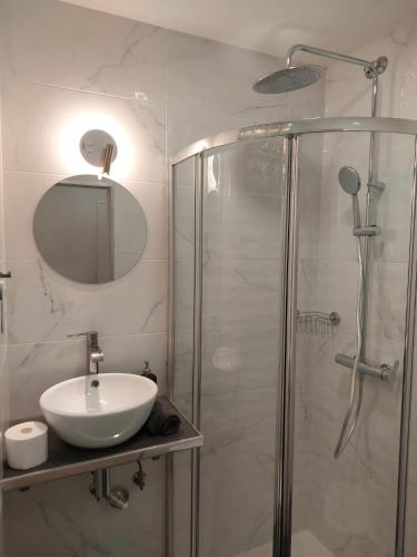 a bathroom with a sink and a shower with a mirror at Lisbon South Bay Rooms in Almada