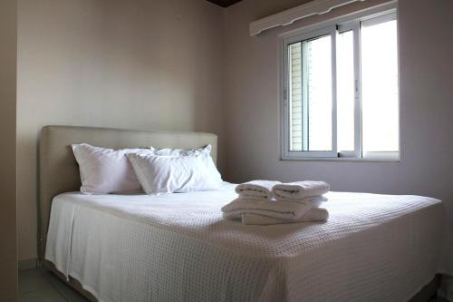 - un lit avec des serviettes et une fenêtre dans l'établissement Eleftheria, à Menídion
