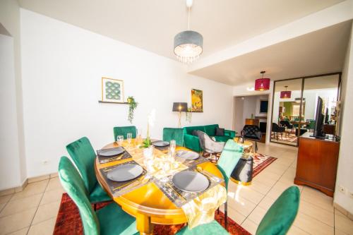 une salle à manger avec une table et des chaises vertes dans l'établissement Nancy Thermal à 2 min -Le 1909- 8 pers- parking chez Julie, à Nancy