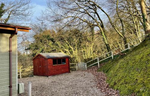 a small red shed sitting next to a fence at The Maples in Narberth