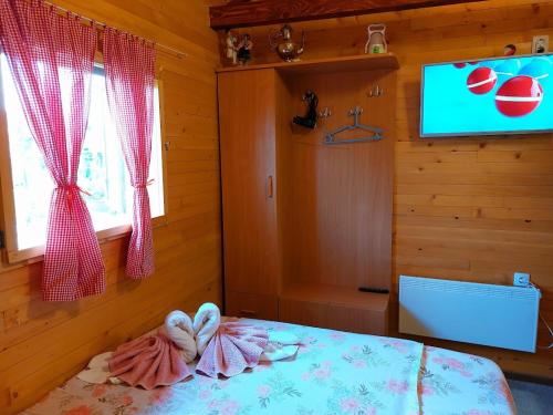 a bedroom with a bed with a tv on the wall at Etno selo EDEN in Žeravački Potok