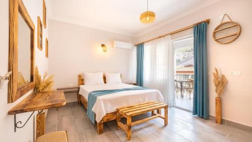 a bedroom with a bed and a table and a window at Larex Otel in Kaş