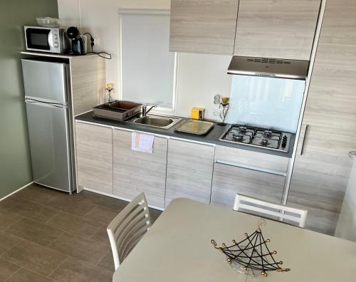 a kitchen with a table and a stove and refrigerator at Chez Mina in Lumio