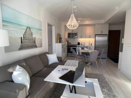 a living room with a couch and a laptop on a table at Stunning Stayz At Friday Harbour Beach Marina Resort Lake Simcoe Innisfil in Innisfil