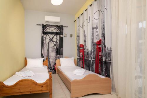 two beds in a room with red telephone booths at Stergios House in Kalamaki