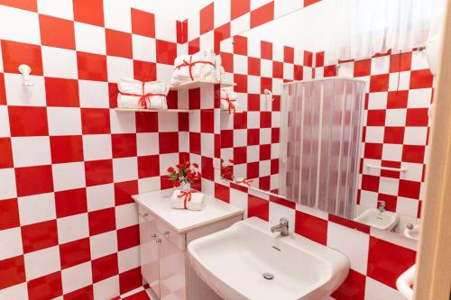 a bathroom with a red and white checkered wall at BDREAMS APARTAMENT in Castellammare di Stabia