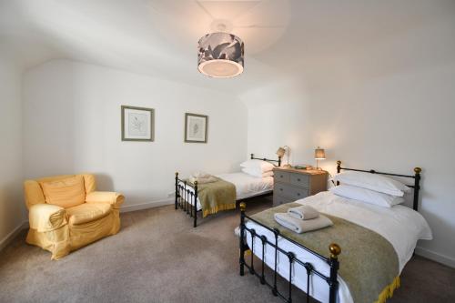a bedroom with a bed and a chair in it at Longhill Farmhouse in Whithorn