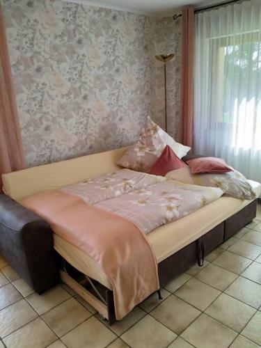 a bed sitting in a room with a window at CasaVitis Erholung am Weinberg in Lontzen