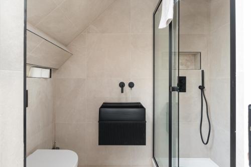 La salle de bains est pourvue d'une douche en verre et de toilettes. dans l'établissement Skyvillion - COZY LARGE 4 Bed Apartments in London Enfield, Mins to Tube Station, Free Wi-Fi, à Cockfosters