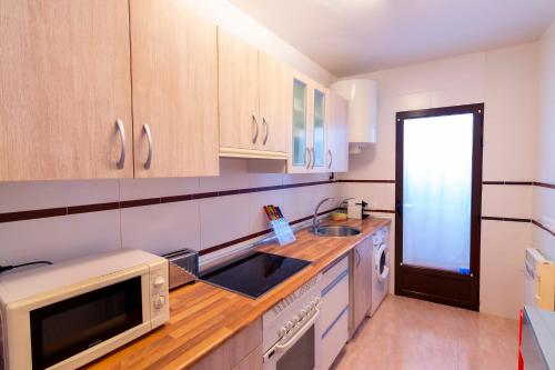 La cuisine est équipée d'un évier et d'un four micro-ondes. dans l'établissement Apartamento El Castillo, à La Adrada