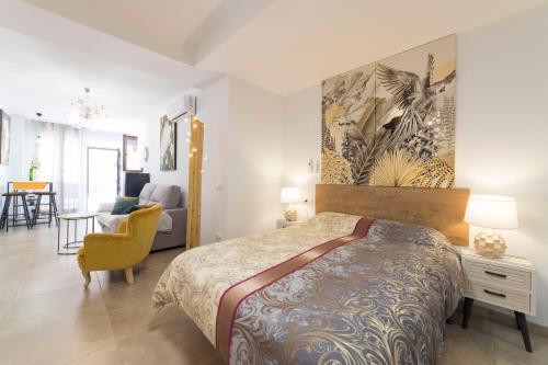 - une chambre avec un lit king-size et une chaise dans l'établissement Precioso Loft El Arcángel II junto a la Ribera, à Cordoue