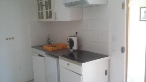 une cuisine avec des armoires blanches et un comptoir dans l'établissement APPARTEMENT DANS HAMEAU PROVENCAL, à Allauch