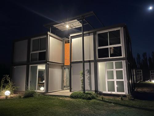 a house with a lot of windows at night at Cubos de Chacras in Ciudad Lujan de Cuyo