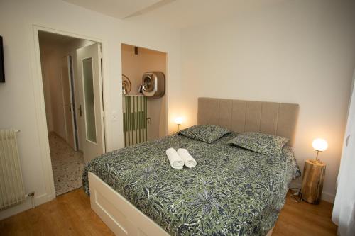Un dormitorio con una cama con dos zapatos blancos. en Fresh&Relax en Chamalières