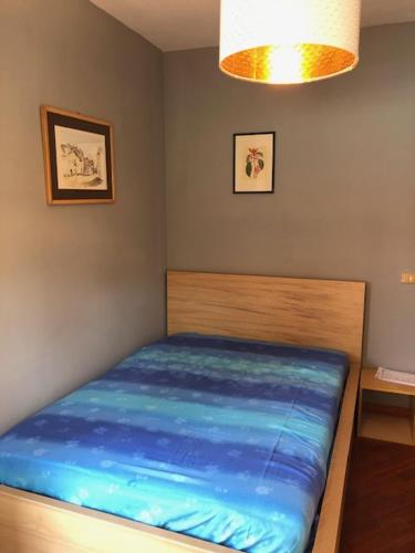 a bedroom with a bed with blue sheets and a light at Scanno Parco naz Abruzzo Nuovo Appartamento I Gerani,300 m dal centro, vista, wifi garage max 7 persone in Scanno