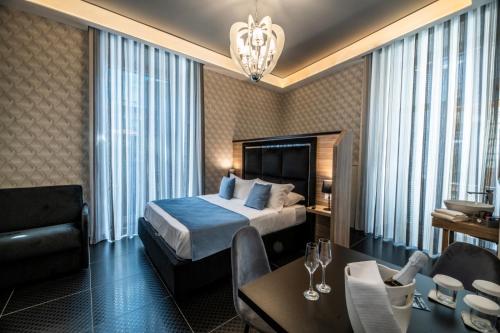 Una habitación de hotel con una cama, una mesa y sillas. en Sole Luxury Bed and Breakfast, en Nápoles