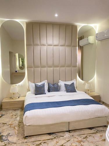 sypialnia z dużym łóżkiem i dużym lustrem w obiekcie Hotel Rest w mieście Abū Qa‘ar