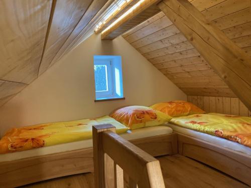 2 Betten in einem Dachzimmer mit Fenster in der Unterkunft Chalupa Střelenka in Janov nad Nisou