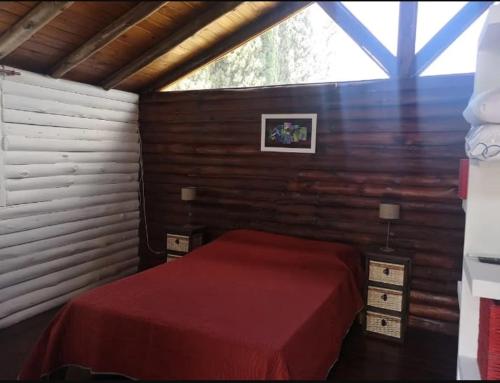 1 dormitorio con cama roja y ventana en Cabañas Qinti en San Pedro