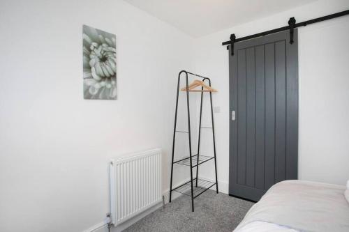 a bedroom with a black door and a ladder at Cudworth House, Barnsley for contractors & Families, off-road parking, speedy WIFI,etc in Barnsley