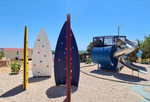 a group of surfboards and a slide on a playground at Mobilna kućica VIA CISSA in Šimuni