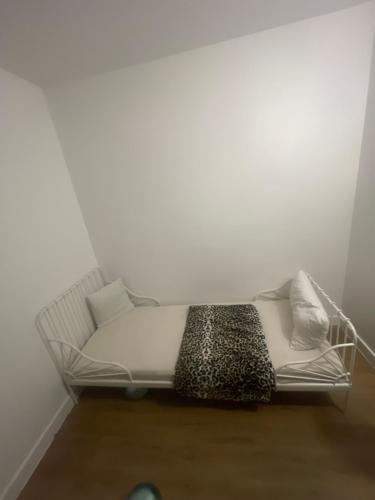 un divano bianco seduto in una stanza con un muro di Appartement chez mounir a Massy