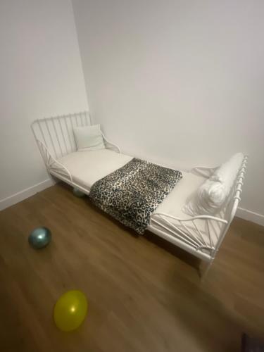 una sedia bianca in una stanza con una palla sul pavimento di Appartement chez mounir a Massy
