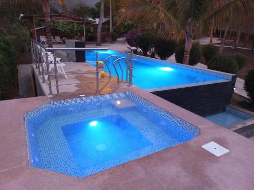 a large swimming pool with two swimming poolsitures at L'Oasis Don Juan in Don Juan