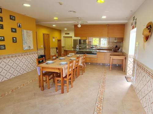 une grande cuisine avec une table et des chaises en bois dans l'établissement Vivenda do relaxo, à Freiria