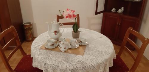 a table with a vase and tea sets on it at Apartman Bogdan in Jelsa