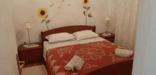 a bedroom with a bed with two tables and two lamps at Apartman Bogdan in Jelsa
