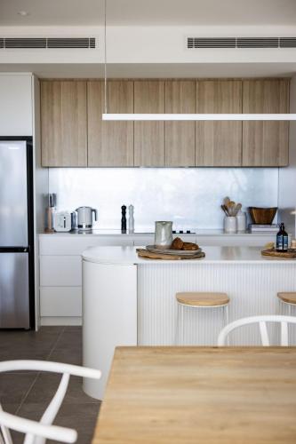 a kitchen with white cabinets and a counter top at 101 on the Beach Jervis Bay in Huskisson