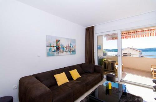 uma sala de estar com um sofá e uma grande janela em Sunny place with sea view em Trogir