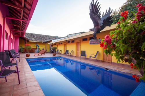 una piscina en un patio con sillas y una casa en Hotel La Calzada, en Granada