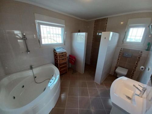 a bathroom with a tub and a sink and a toilet at Villa Delia in Okurcalar