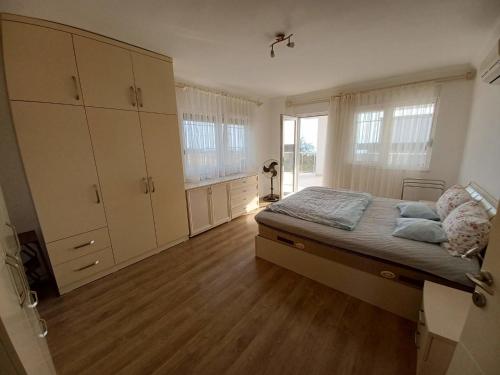 a bedroom with a bed and a large window at Villa Delia in Okurcalar
