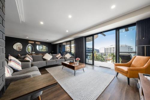 a living room with a couch and a table at Ocean View Spacious Luxury 3 Bedroom, Pool, Central, Walk everywhere 6PM CHECKOUT in The Entrance