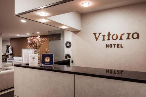 a hotel lobby with a vitoria hotel sign on the wall at Vitoria Hotel in Fátima