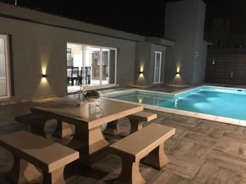 una piscina con una mesa y un banco junto a ella en Loft las rosas, en Villa María