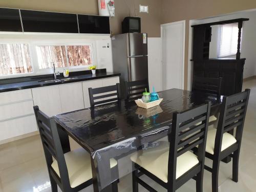a kitchen with a black table with chairs and a refrigerator at Loft las rosas in Villa María