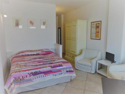 a bedroom with a bed and a chair at Red - Monolocale San Pantaleo in San Pantaleo