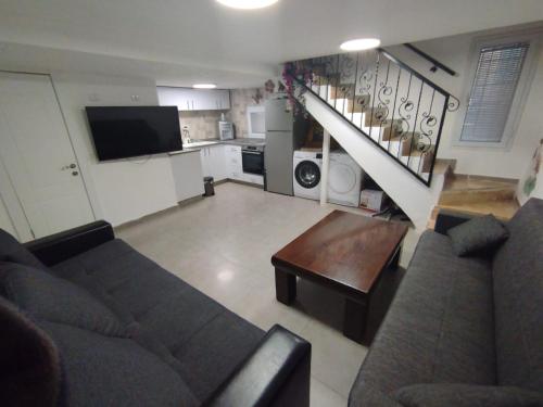 a living room with a couch and a table at Magical old city apartment דירת אירוח מקסימה בלב הרובע היהודי in Jerusalem