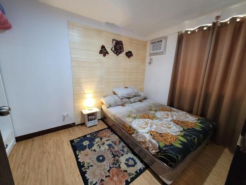 a small bedroom with a bed and a rug at Arezzo Davao Near Sm Lanang & Airport in Davao City
