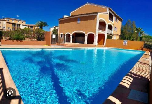 una grande piscina di fronte a una casa di Modern, 2 bedrooms, Aircon, pool & fiber optic in a quiet, private gated domain 5kms to St Tropez a Cogolin