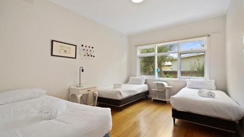 a bedroom with two beds and a window at Jetty Road on the Beach in Lakes Entrance