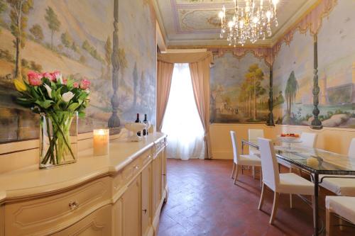 a dining room with a table and a vase of flowers at Dimora Bandinelli in Florence