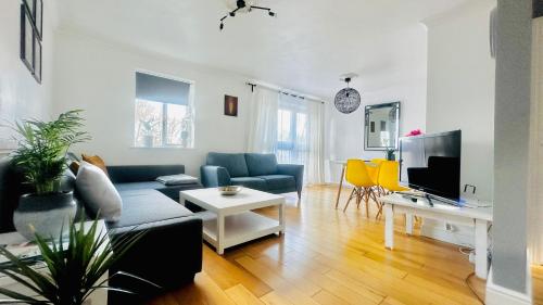 Una sala de estar con un sofá y un televisor. en Amazing Location - City of London- 2 Bedroom Stunning Canal View House With Private Garden,Parking & Balcony, en Londres