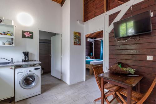 a kitchen with a washing machine and a table at Gîtes de la coulisse in Trois-Rivières