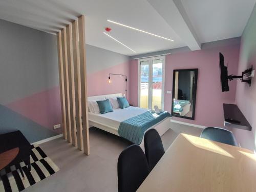 um quarto com uma cama e uma parede rosa em Social Lodge - Happiness em Funchal